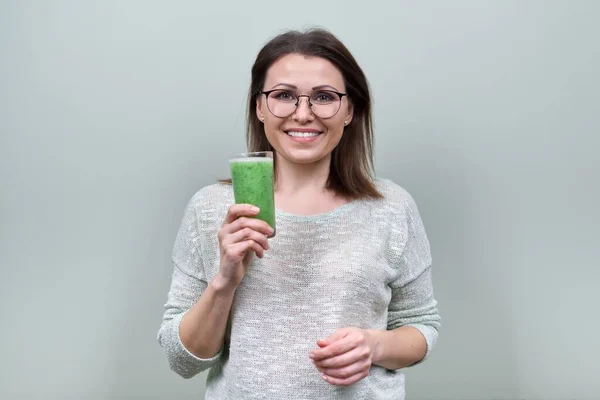 Mulher madura com bebida smoothie vegetal verde, dieta vegan saudável — Fotografia de Stock