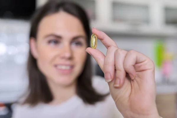 Young beautiful woman taking pill vitamin a, d, e, fish oil, omega-3 — Stock Photo, Image