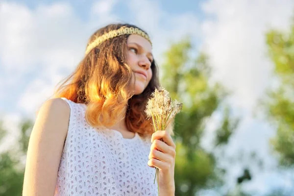 Tonårstjej med hippie frisyr håller torra maskrosor i handen — Stockfoto