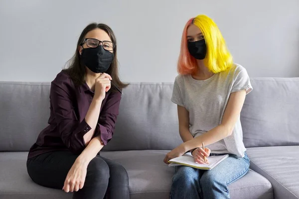 Profesor trabajando con estudiante universitario, con máscaras protectoras negras —  Fotos de Stock