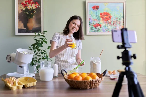 Girl teenager food blogger recording recipe for cooking orange pancakes