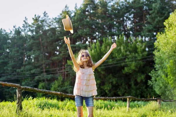 Gelukkig meisje genieten van de zomervakantie, kind in de natuur op groene weide spelen met hoed — Stockfoto