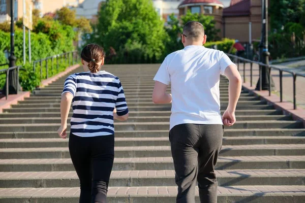 Paar rennende op de trap in de stad achteraanzicht — Stockfoto