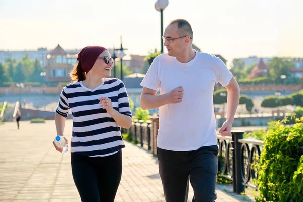 Par som springer i stan, mogna män och kvinnor tillsammans — Stockfoto