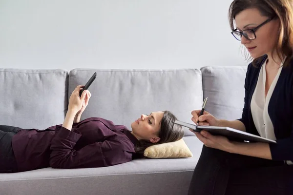 Jeune femme en consultation avec un psychologue. Patiente couchée sur le canapé — Photo