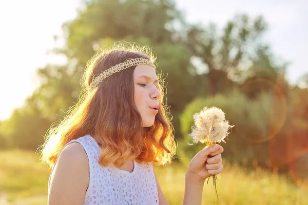 在干蒲公英上吹嬉皮士发型的少女. — 图库照片