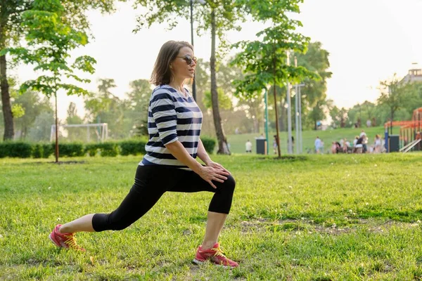 Idősebb nő, aki fitnesz gyakorlatokat végez a parkban — Stock Fotó