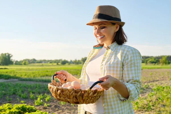 Porträtt av bonde kvinna i hatt med korg av färska ägg — Stockfoto