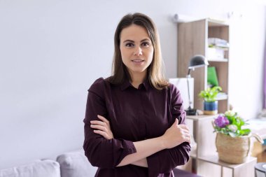 Ofiste kollarını kavuşturmuş kendine güvenen genç bir zihinsel terapistin portresi.