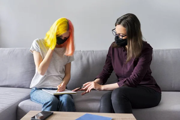 Profesor trabajando con estudiante universitario, con máscaras protectoras negras —  Fotos de Stock