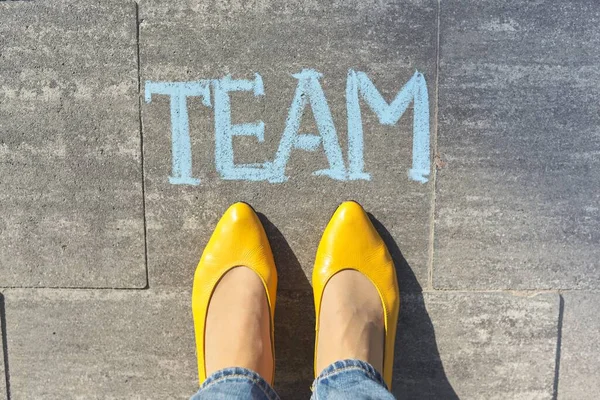 Koncept týmu, pohled shora na ženské nohy a text psaný křídou na šedém chodníku — Stock fotografie