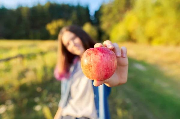 Νεαρή ευτυχισμένη γυναίκα με κόκκινο μήλο, που δαγκώνει ένα μήλο — Φωτογραφία Αρχείου