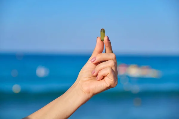 Capsule of vitamin d, e, a, omega 3, fish oil in the hand close-up — Stock Photo, Image