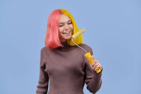Menina bonita pinta seu cabelo com rolo de construção — Fotografia de Stock