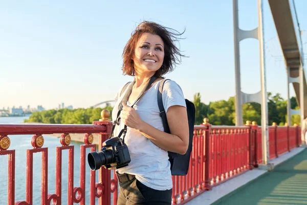 Dojrzałe kobieta fotograf z profesjonalny aparat fotograficzny i plecak — Zdjęcie stockowe