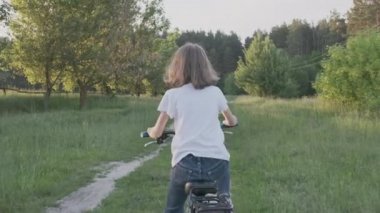 Çocuk bisiklete biniyor, kızlar ilk bisiklete biniyor başarı, günbatımı kır yolu, doğal manzara, arka plan
