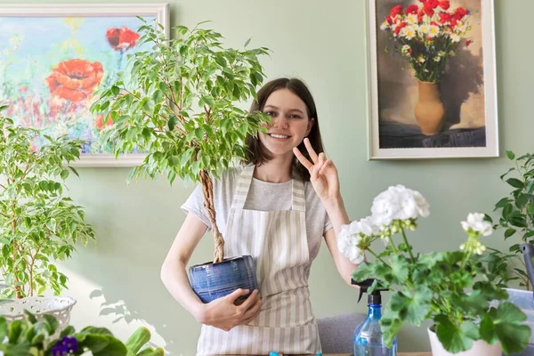 Портрет красивой улыбающейся девочки-подростка с растениями в горшках . — стоковое фото