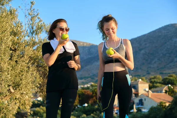 Atletisch gezond gezin levensstijl, gelukkig moeder en tienerdochter eten appels — Stockfoto