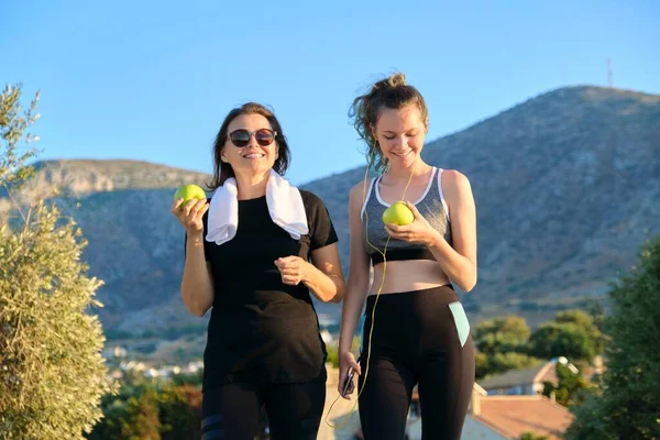 Atletisch gezond gezin levensstijl, gelukkig moeder en tienerdochter eten appels — Stockfoto