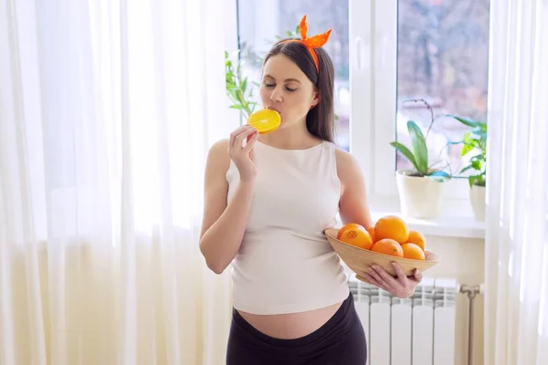 Alimentos vitamínicos saudáveis, bela jovem grávida feliz com laranjas — Fotografia de Stock