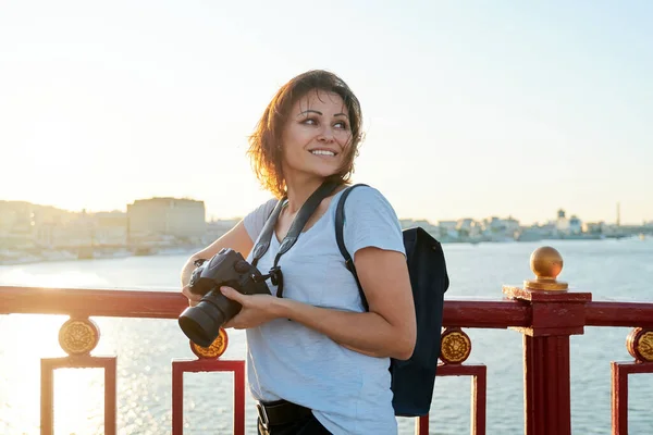 Dojrzałe kobieta fotograf z profesjonalny aparat fotograficzny i plecak — Zdjęcie stockowe