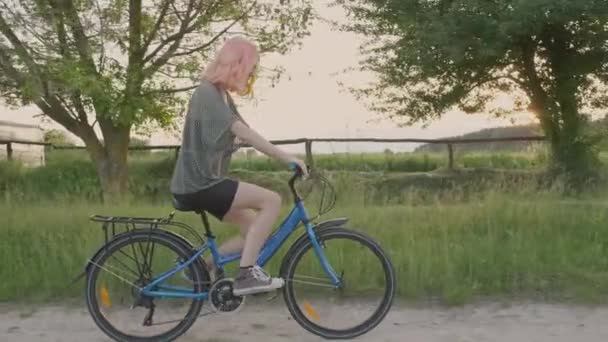 여름활기찬 휴가, 행복 한 십 대 소녀 자전거타기, 염색 한 머리를 가진 유행하는 힙합 가수타기 와 자연을 즐기는 시골 배경 — 비디오