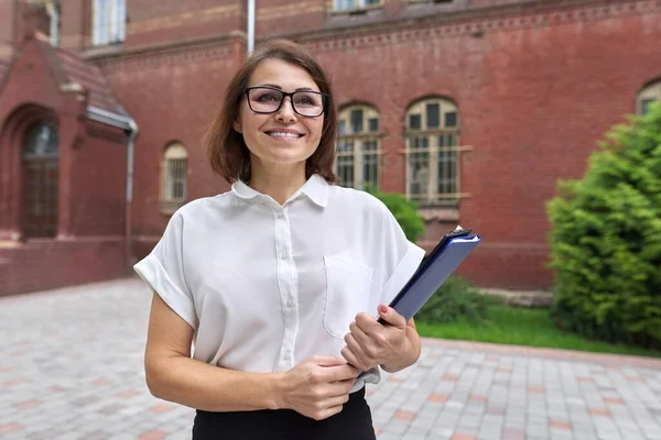 Porträt einer selbstbewusst lächelnden Geschäftsfrau, Lehrerin, Beraterin mit Klemmbrettpapier — Stockfoto