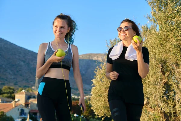 Atletisch gezond gezin levensstijl, gelukkig moeder en tienerdochter eten appels — Stockfoto