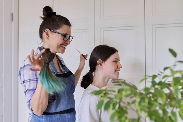 Corte de pelo en casa, mamá corta el pelo de las hijas, mujer corta el pelo teñido poco saludable —  Fotos de Stock