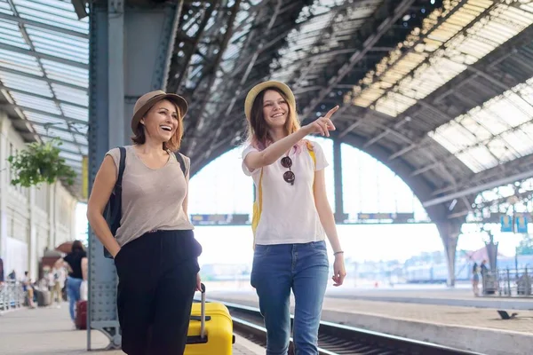 Mãe feliz e filha adolescente andando com mala na estação ferroviária — Fotografia de Stock