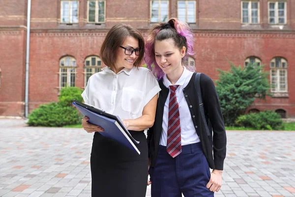 Outdoor portret van pratende vrouwelijke leraar en student tiener — Stockfoto