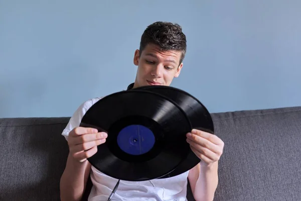 Креативный подросток с виниловыми пластинками, молодой человек в наушниках интересуется музыкой — стоковое фото