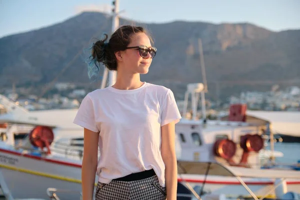 Красива модна дівчина-підліток, що йде уздовж морської набережної, пірс з яхтами — стокове фото