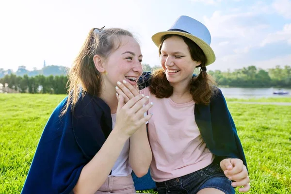 Vriendinnen tieners hebben plezier zittend op gras op zonnige zomerdag — Stockfoto