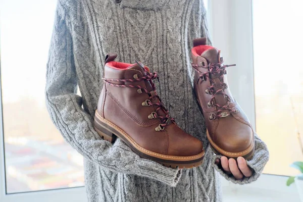 New womens leather brown waterproof winter boots in hands of female