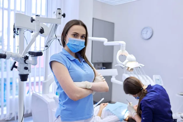 Портрет впевненої жінки-стоматолога в медичній масці з схрещеними руками — стокове фото