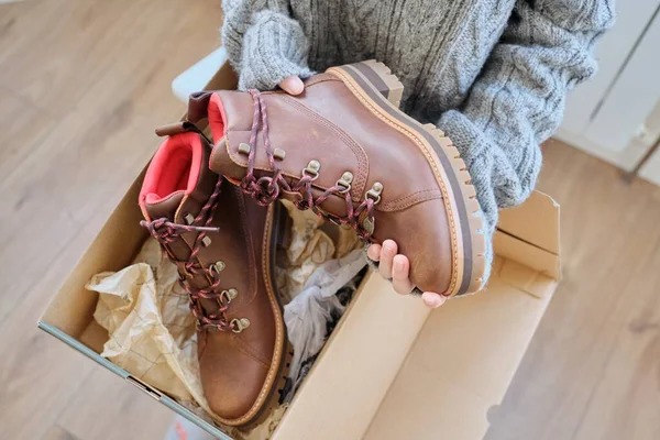 New womens leather brown waterproof winter boots in hands of female