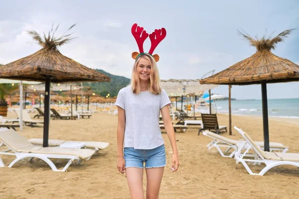 Όμορφη νεαρή γυναίκα που περπατά στην παραλία στα αυτιά ελαφιού των Χριστουγέννων — Φωτογραφία Αρχείου