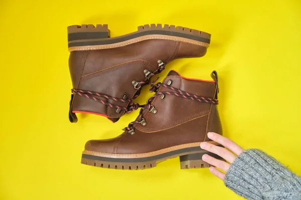 Nuevas botas de invierno impermeables de cuero marrón para mujer sobre fondo amarillo —  Fotos de Stock