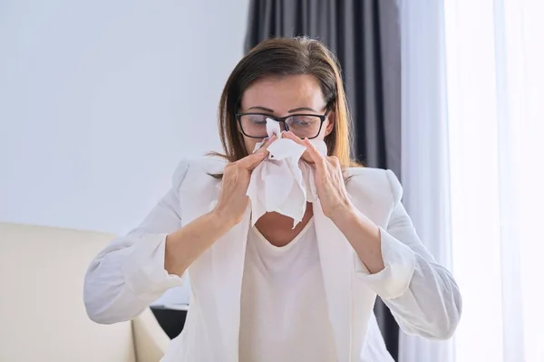 Mujer estornuda en el pañuelo, mujer de negocios se enfermó en la oficina —  Fotos de Stock