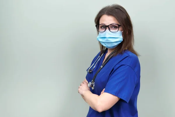Портрет впевненого лікаря-жінки зі стетоскопічною маскою в блакитній формі — стокове фото