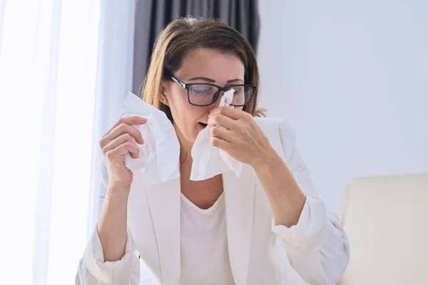 Woman sneezes in handkerchief, businesswoman got sick in the office — Stock Photo, Image