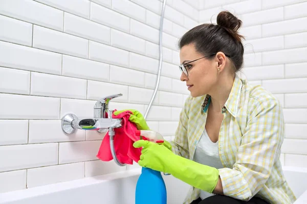 Frau in Handschuhen mit Waschmittel und Lappen beim Badputzen — Stockfoto