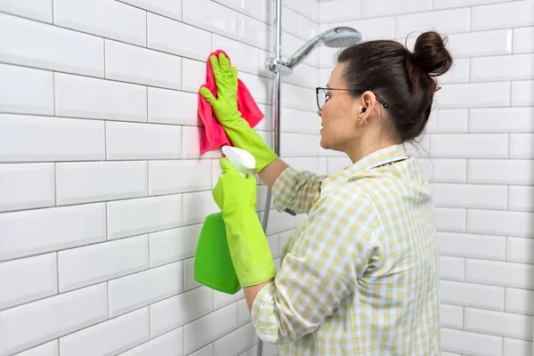 Badkamer schoonmaken, huisvrouw wassen witte tegel muur met wasmiddel en doek — Stockfoto