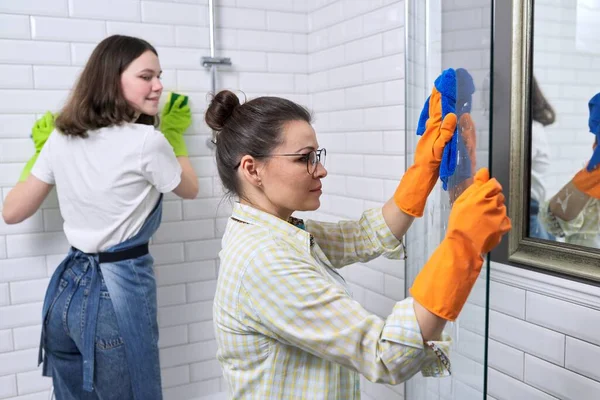 Mother and teenage daughter cleaning together in bathroom — Stock Photo, Image