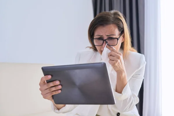Sick businesswoman sneezing in handkerchief making video call