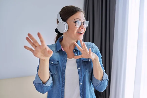 Portrét dospělé pozitivní mluvící ženy ve sluchátkách — Stock fotografie