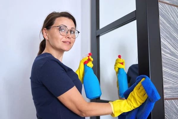 Hausreinigung, reife Frau putzt zu Hause im Wohnzimmer — Stockfoto
