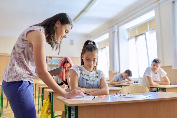 Преподаватель-молодая женщина преподает урок в классе подростков — стоковое фото