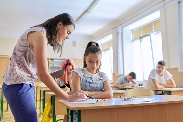 Genç bayan öğretmen, ergen çocuklar sınıfında ders veriyor. — Stok fotoğraf